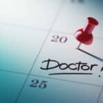 Calendrier avec une punaise qui indique un rendez-vous chez le médecin