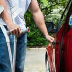 Homme en situation d'handicap physique qui ouvre la portière d'une voiture