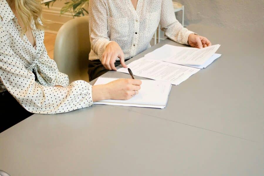 Personne qui signe un papier et une personne aidant cette dernière