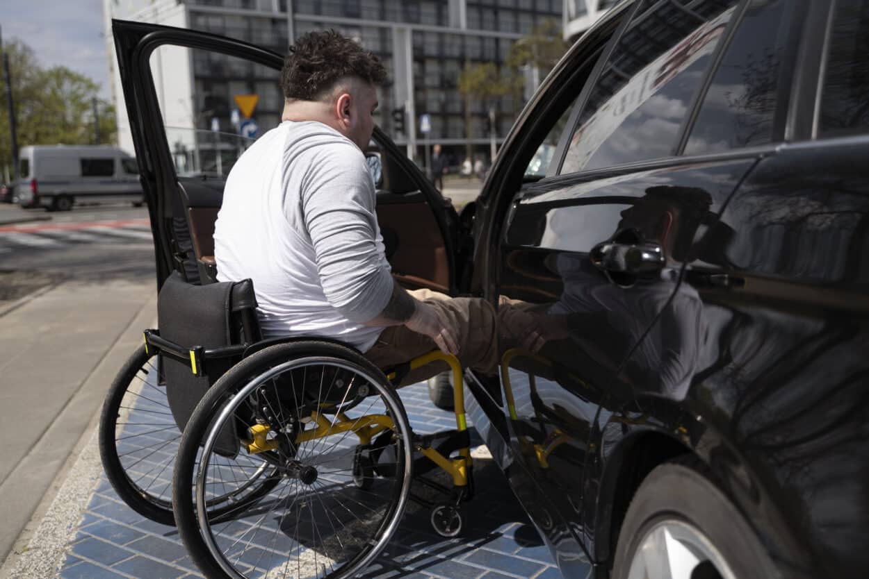 personne en fauteuil roulant montant dans son véhicule